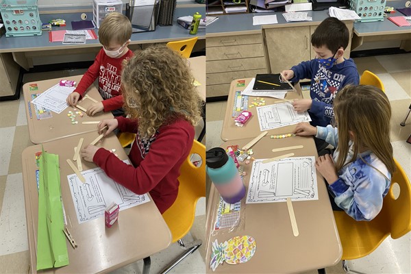 2nd graders working on Valentine STEM challenge building bridges with popsicle sticks and candy hearts.